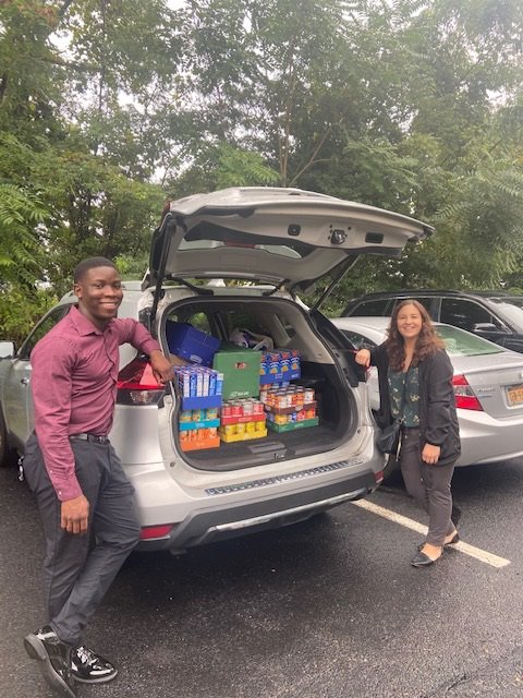 Madison Trust employees with a car trunk full of items to donate to the food pantry.