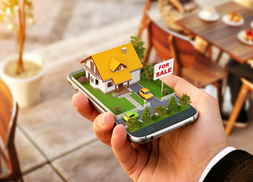 Investor holding a smart phone with a 3D image of a house for sale, indicating a real estate investment option.