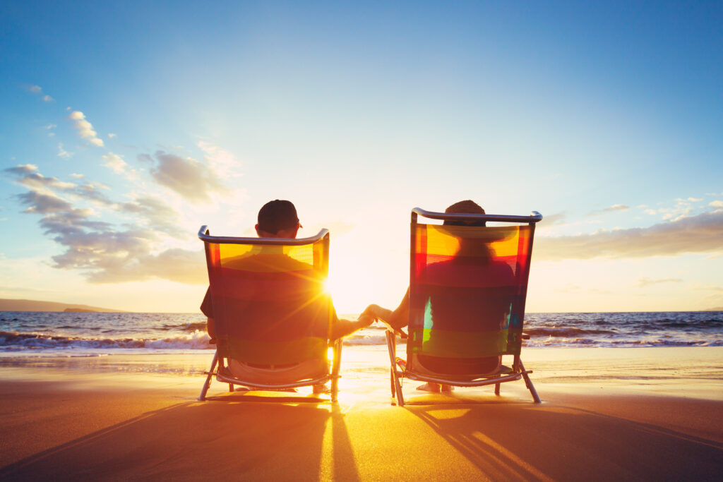 Couple-sitting-in-beach-chairs-during-sunset