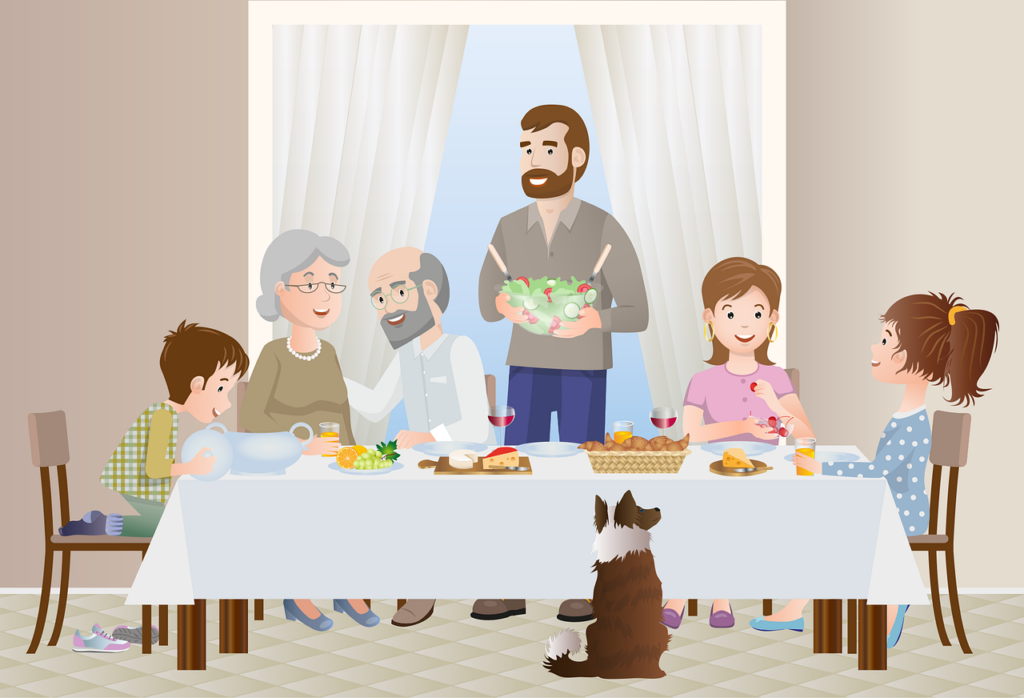 Family of grandparents, parents and child, with a dog, sitting at a table in a home eating a meal
