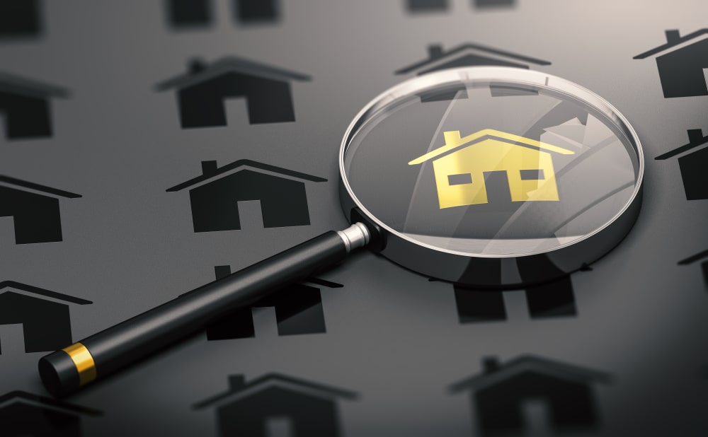 Magnifying glass over a gold icon depicting a house