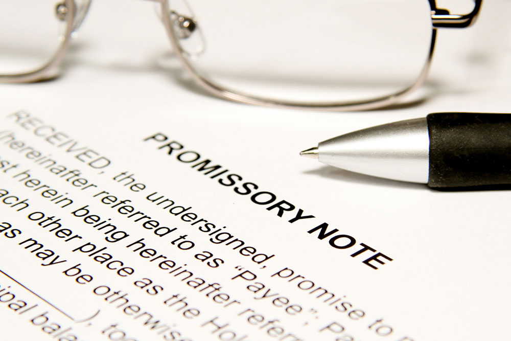 Promissory Note document, pen, and glasses. 