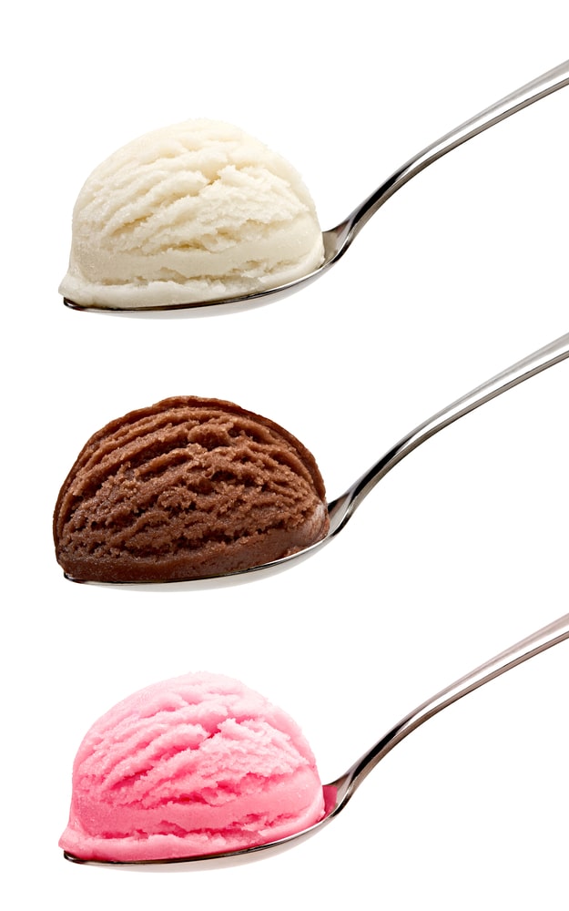 Three spoons: one with a scoop of vanilla ice cream, one with chocolate, and one with strawberry ice cream