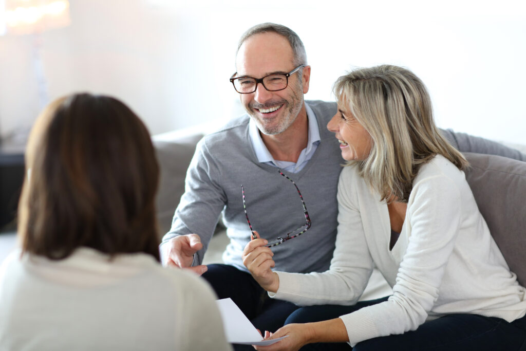 Happy couple and Self-Directed IRA investors meeting with a Self-Directed IRA custodian about their investments, showing that you do not need to be an accredited investor to have a Self-Directed IRA.