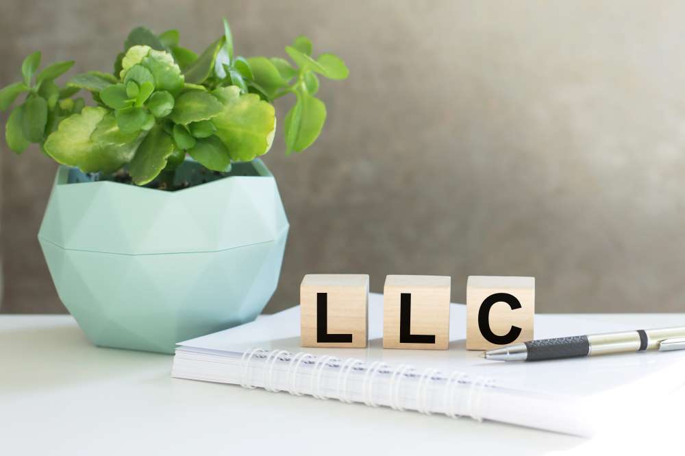 wooden blocks with "LLC" sitting on a notebook