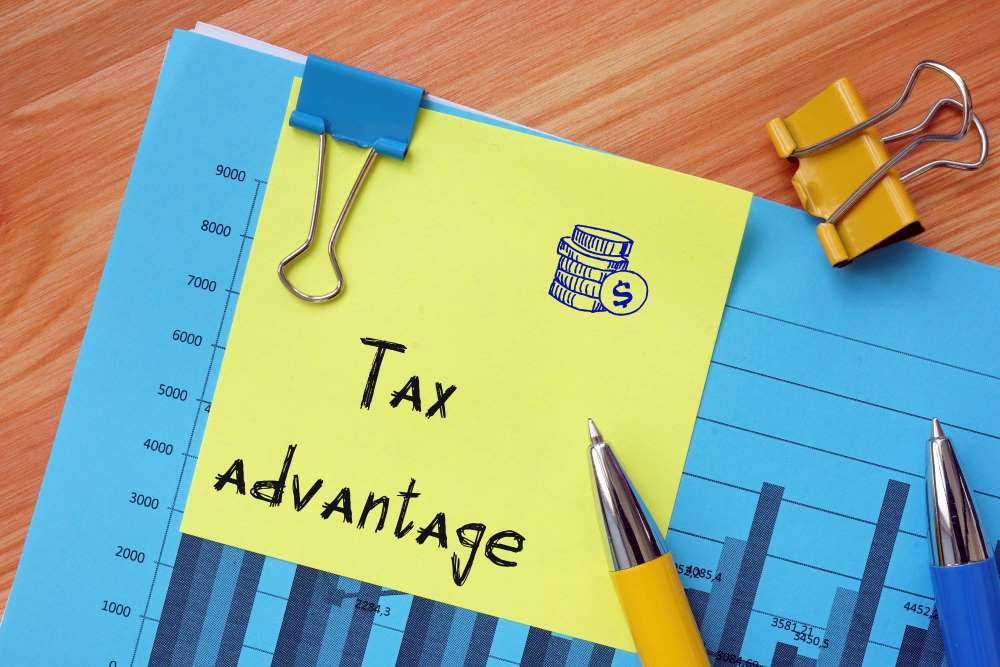 A folder and graph perched on top of a desk, with a post-it note labeled “tax advantages.” This indicates the tax benefits available through a Self-Directed IRA, including your money growing tax-free or tax deferred.