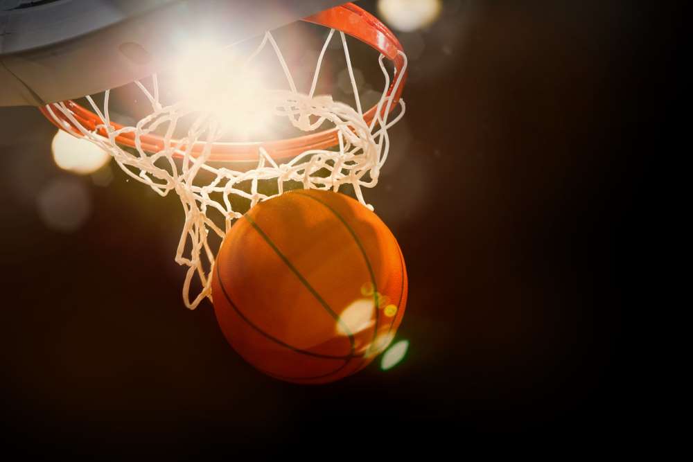 A basketball swishes through a hoop, indicating that investing with a Self-Directed IRA is a slam dunk.
