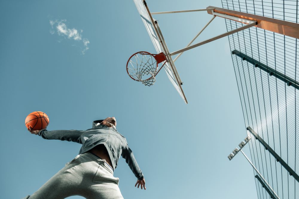 A low-angled shot of a basketball player about to score a basket, solidifying that with a Self-Directed IRA, your future has the potential to be secure.