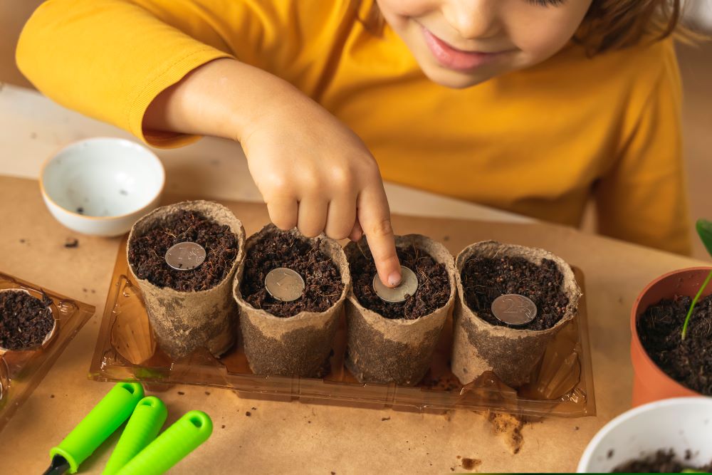 Another child fills flowerpots with soil and coins, demonstrating that planting seeds for your retirement early through vehicles such as the Self-Directed IRA may prove to be beneficial.