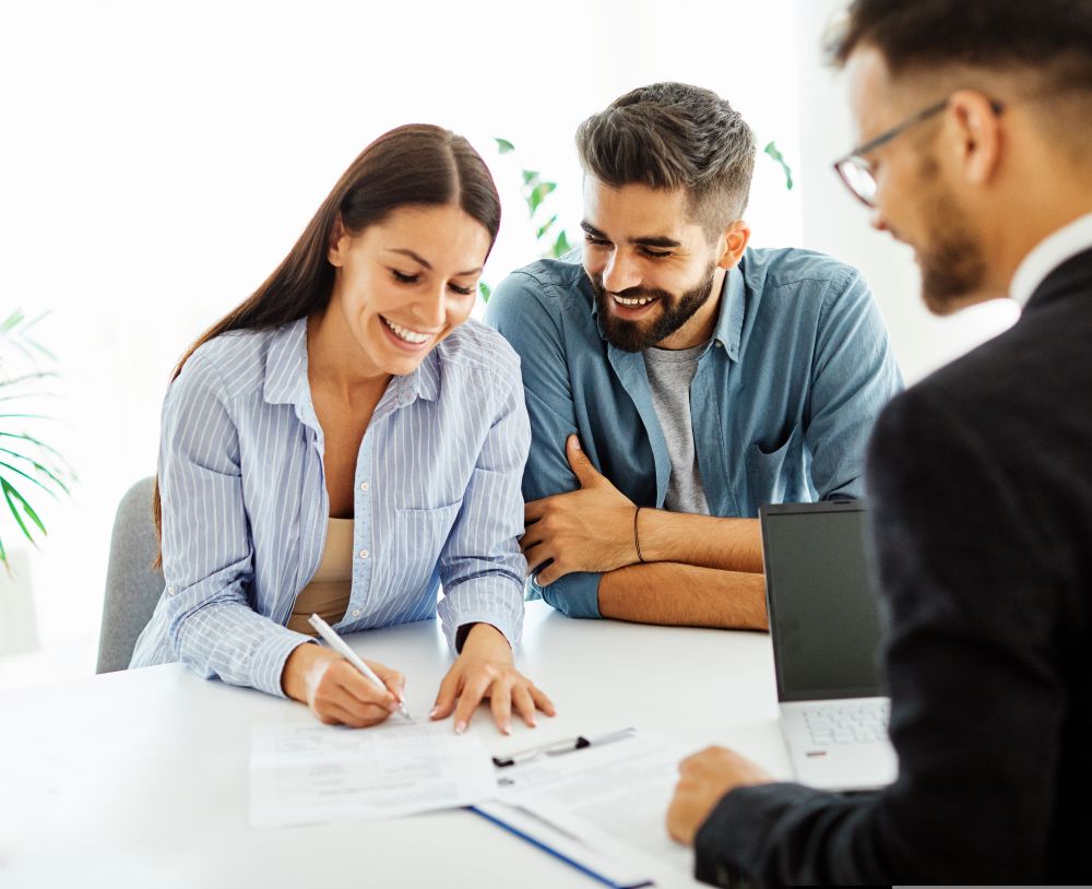 Self-Directed IRA investors with a Self-Directed IRA custodian signing papers for their real estate investment in their retirement account.